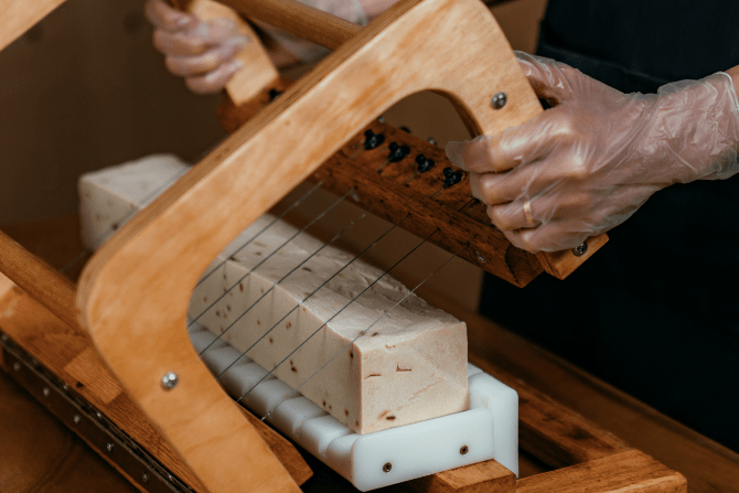 Wooden soap cutter distributing Rough Beauty soap bars into equal pieces